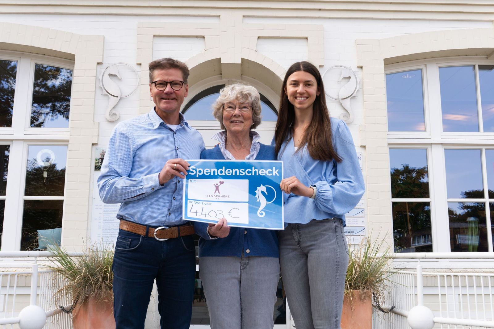 Drei Personen präsentieren Kunstauktion