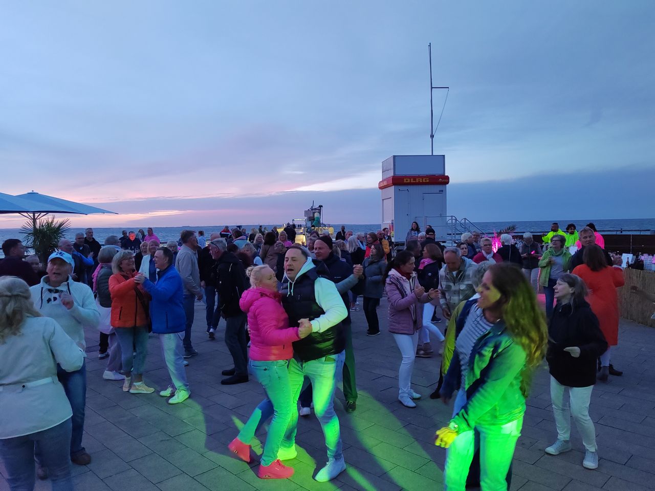 Tanzende Menschen auf der Strandpromenade