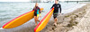 Frau und Mann im Neoprehnanzug am Strand mit Stand up paddel Boards