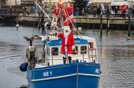 Fischers Wiehnacht wird traditionell durch den Weihnachtsmann eröffnet, der auf einem Fischerboot in den Niendorfer Hafen einfährt.