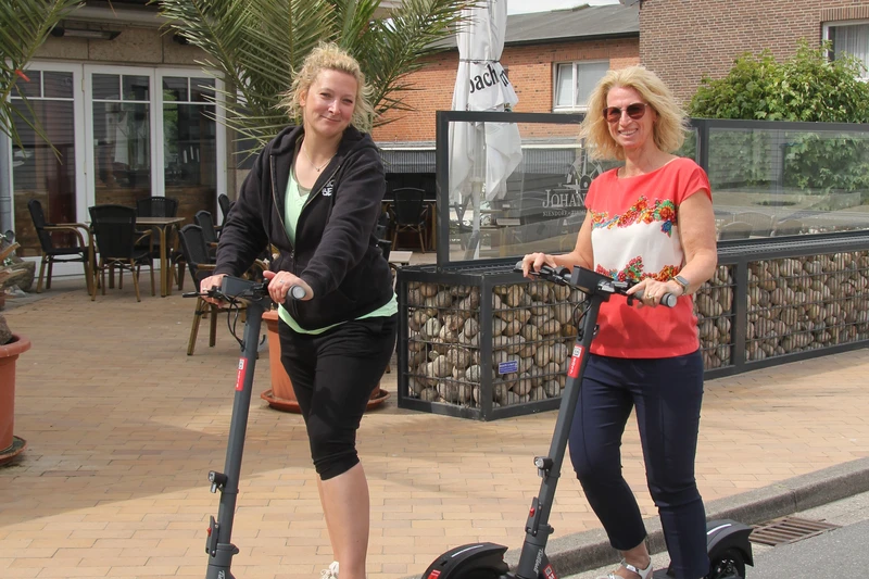 Zwei Frauen auf E-Scootern in der Innenstadt