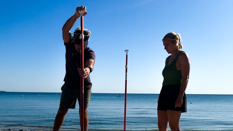 Surflehrer Andreas zeigt Lara wie man Sub fährt.