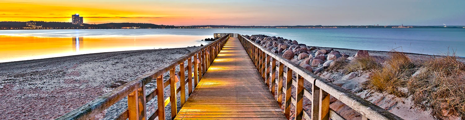 Steg am Strand im Sonnenuntergang