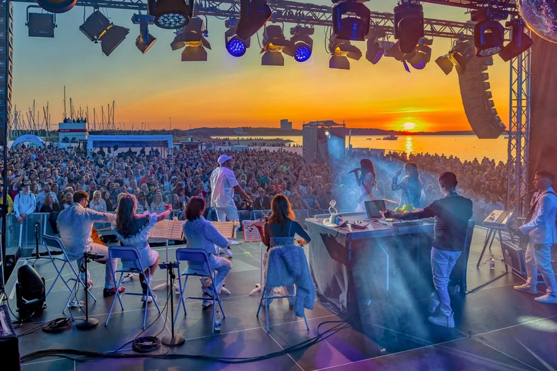 Foto eines Konzertes bei Sonnenuntergang von der Bühne aus fotografiert.