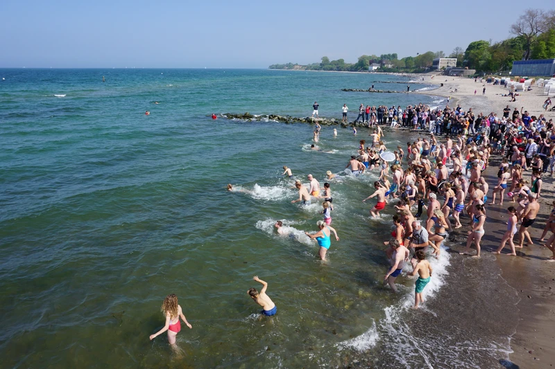 Eine große Menge Menschen strömt ins Wasser