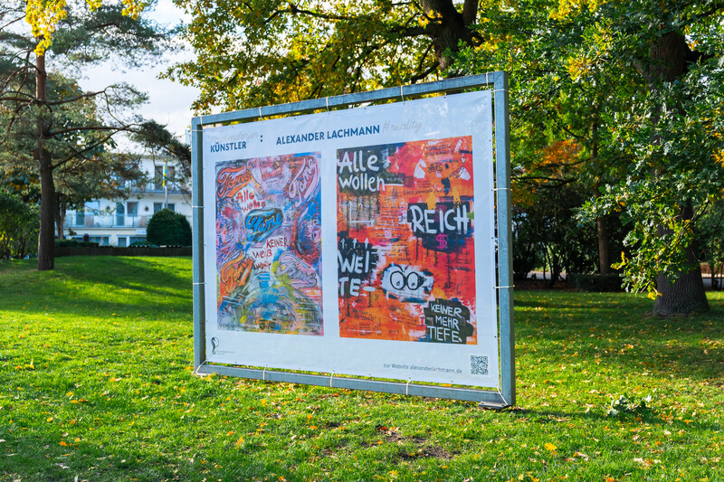 Im großen Stahlrahmenbanner im Strandpark sind die Kunstwerke der beiden Künstler abgebildet
