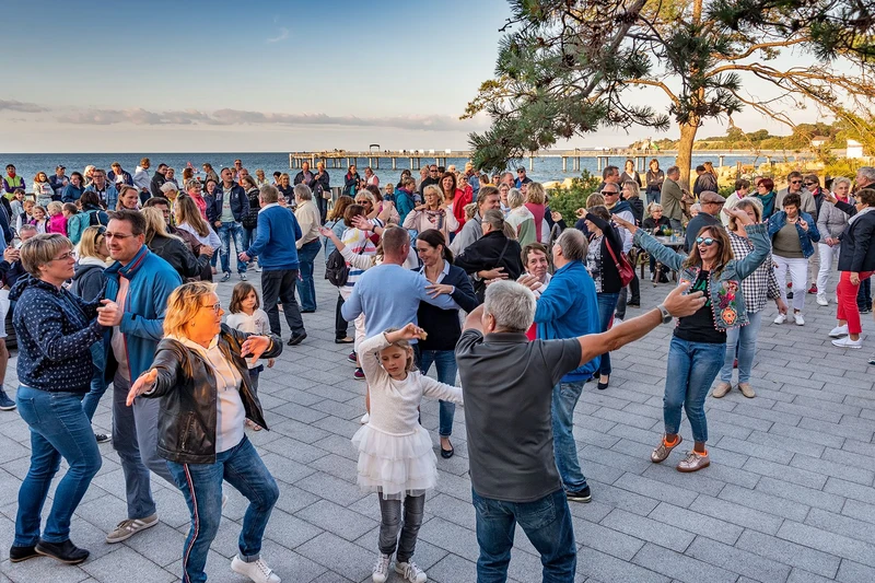 Viele Menschen tanzend auf der Strandpromenade