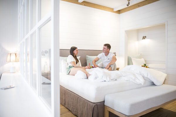 Bild auf dem 2 Gäste im Hotelzimmer auf dem Bett liegen