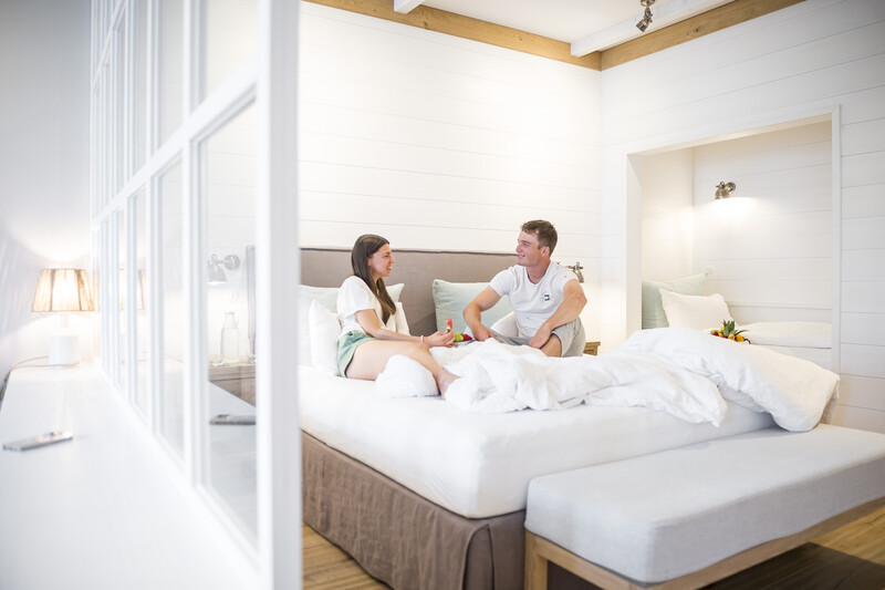 Bild auf dem 2 Gäste im Hotelzimmer auf dem Bett liegen