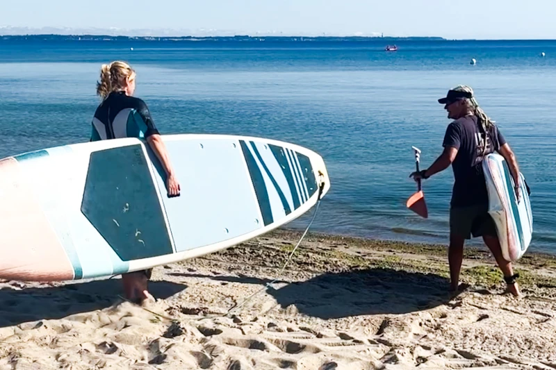 Surfleher Andreas und Redakteurin Lara gehen mit einem Sub ins Meer.