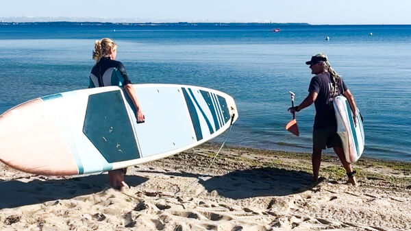 Surfleher Andreas und Redakteurin Lara gehen mit einem Sub ins Meer.