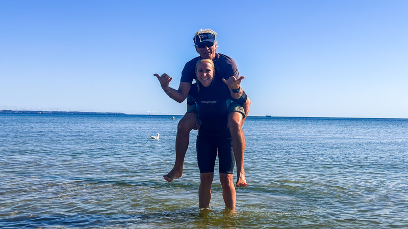 Lara Klewin trägt Surflehrer Andreas auf den Schultern. 