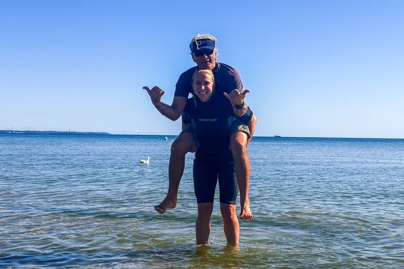Lara Klewin trägt Surflehrer Andreas auf den Schultern. 