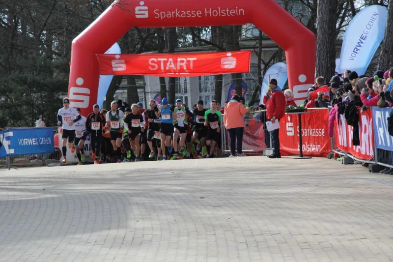 Startbereich eines Laufs mit großem roten Torbogen von der Sparkasse Holstein