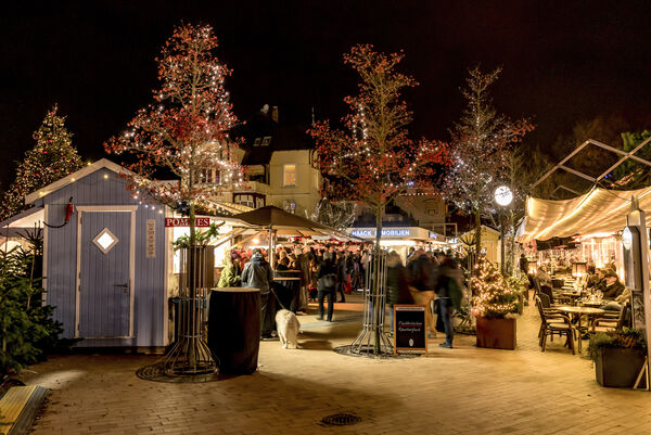 Beleuchtete Buden und Bäume auf dem Weihnachtsmarkt auf dem Timmendorfer Platz