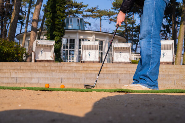 jemand hat einen Golfschläger in der Hand und schlägt den Ball