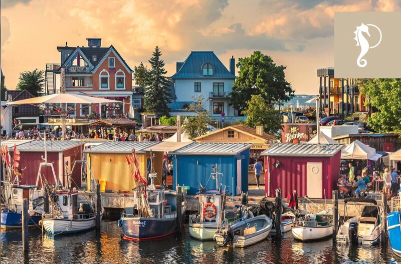 Bunte Fischerkütten und -kutter im Niendorfer Hafen bei Sonnenuntergang