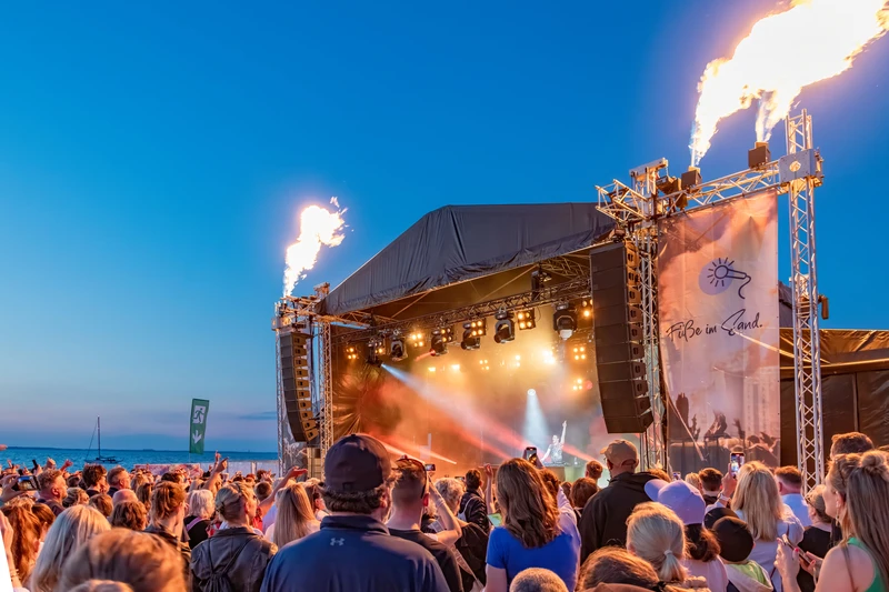 Konzertbühne mit Pyrotechnik, Abendstimmung und viele Zuschauer