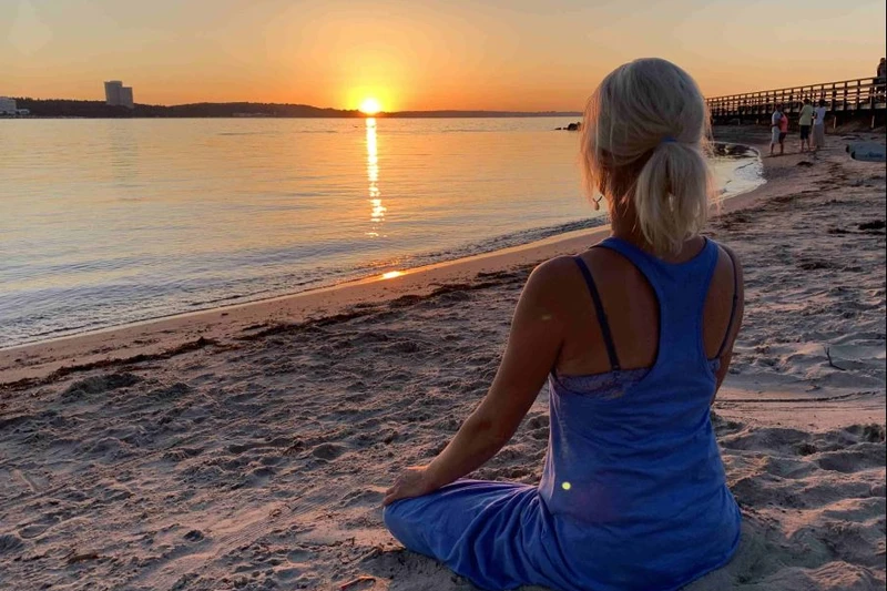 Eine Frau macht Yoga am Strand