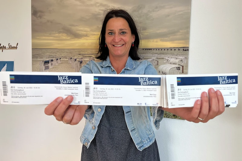 Eine Frau hält drei Jazz Baltica Tickets in die Kamera