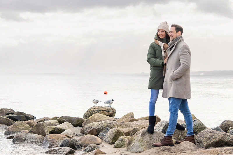 Pärchen steht im Winter an der Ostsee