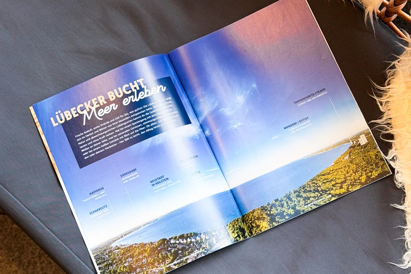 Ein Magazin was aufgeklappt liegt und die Lübecker Bucht zeigt