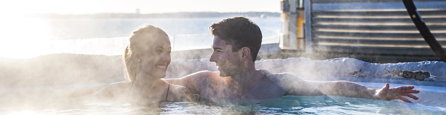 Pärchen in einem heißen Pool umgeben von Nebel