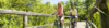 Pärchen auf Fahrrädern fährt über die Holzbrücke.