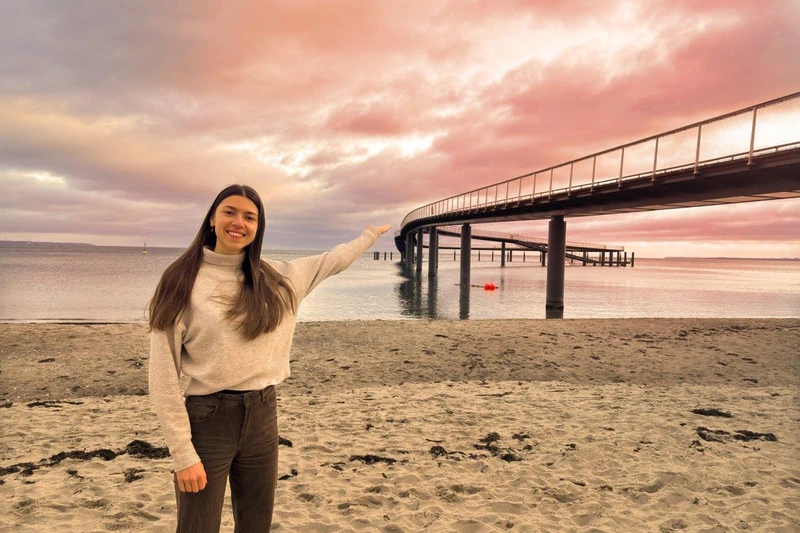 Frau präsentiert die neue Seebrücke von Timmendorfer Strand