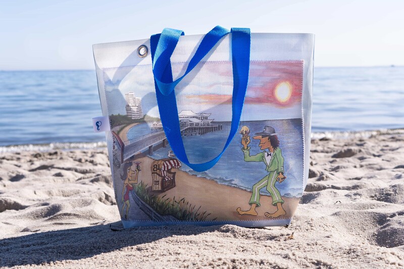 Upcycling-Tasche steht im Sand am Strand. 