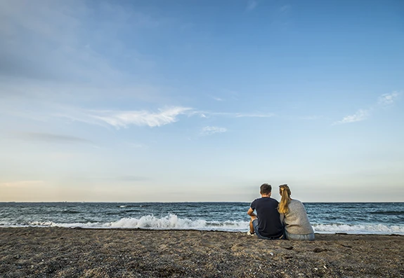 Pärchen sitzt am Strand und genießt die Weite