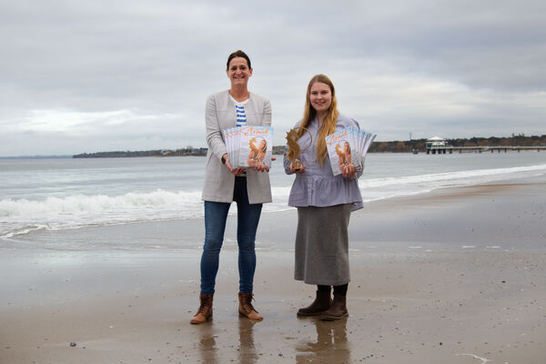 Silke Szymoniak und Lale Schoenberg mit dem Strandmagazin2024 in der Hand am Strand