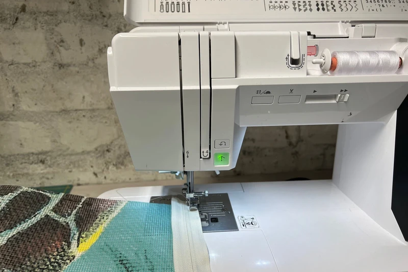 Eine Nähmaschine näht Stoff zusammen. 