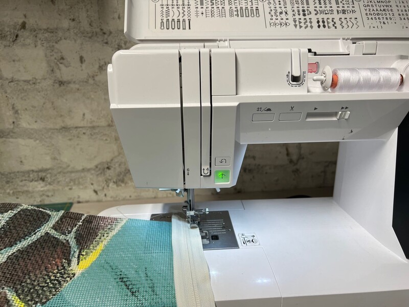 Eine Nähmaschine näht Stoff zusammen. 