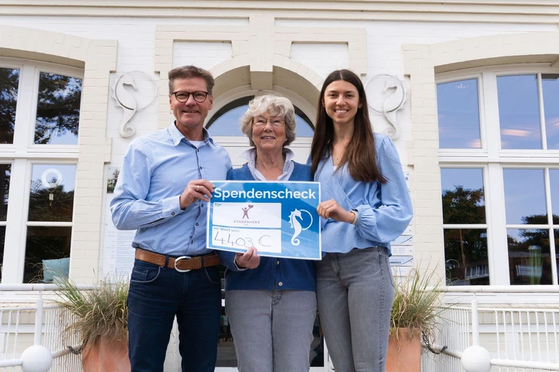 Drei Personen präsentieren Kunstauktion