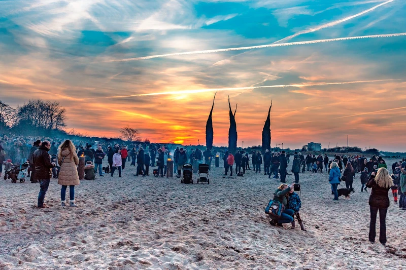 Viele Menschen bei Sonnenuntergang am Strand