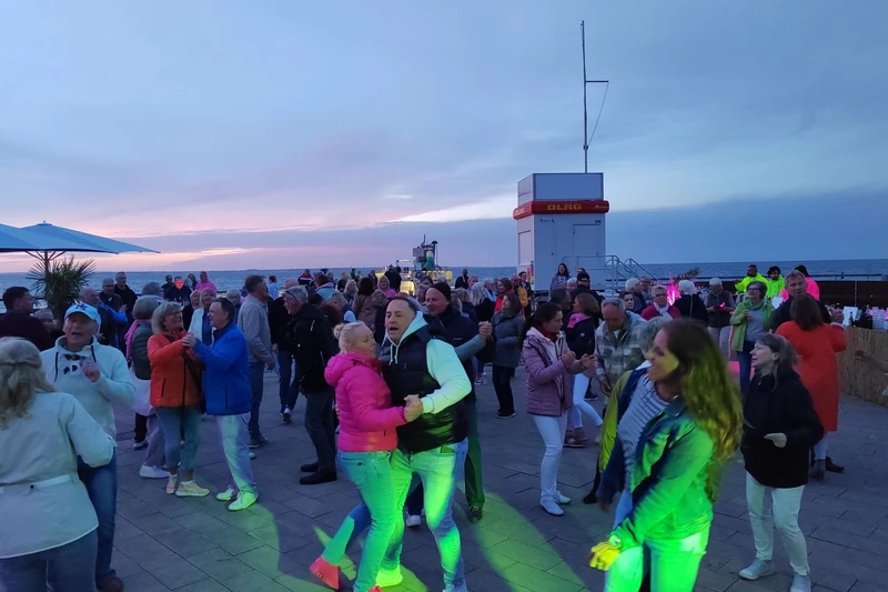 Tanzende Menschen auf der Strandpromenade