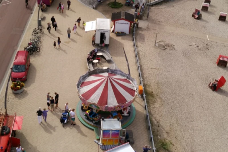 Festmeile aus der Luft fotografiert. Zu sehen ist ein Karussell, Feuerwehrautos und viele Menschen.