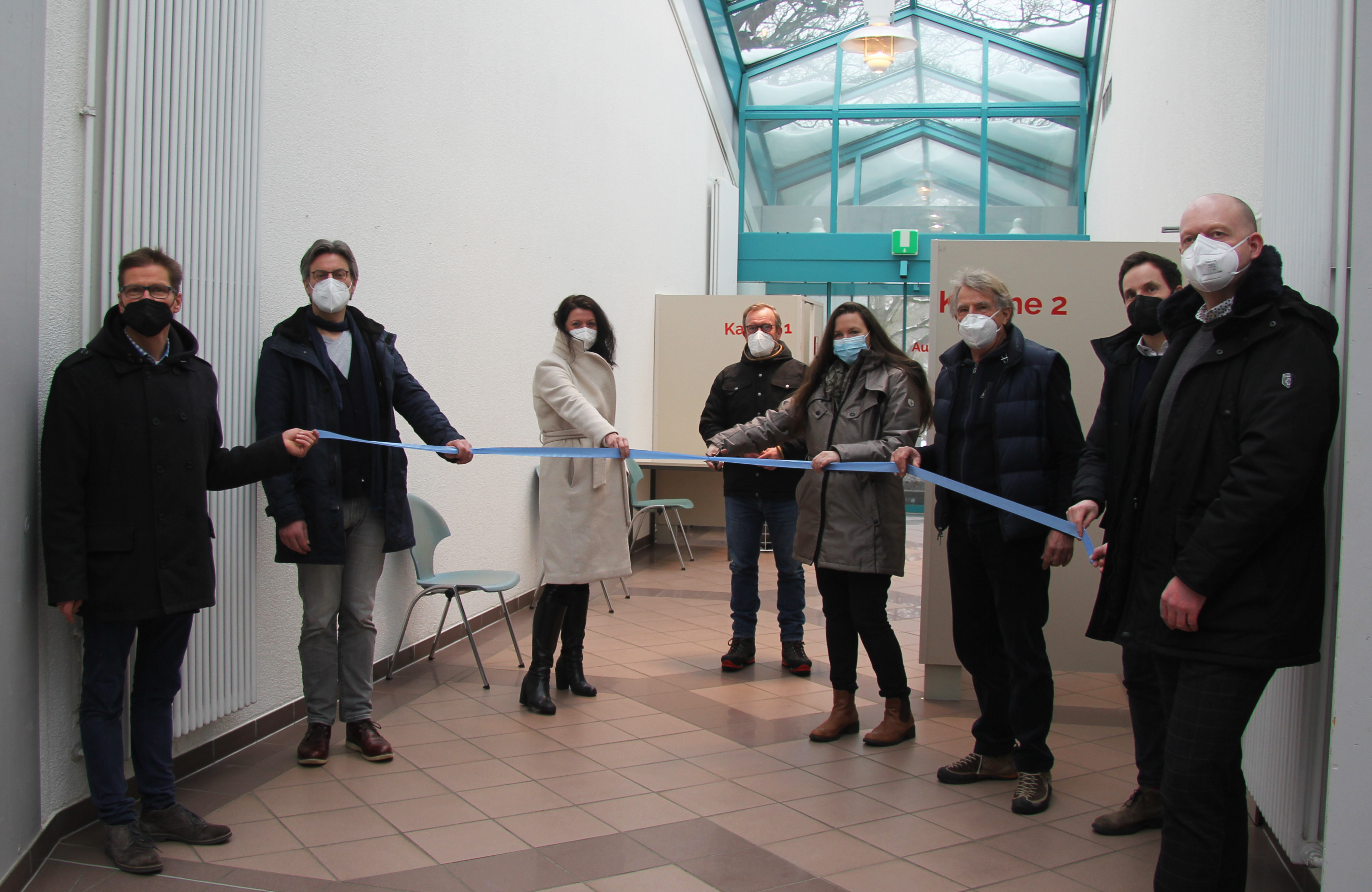 Acht Personen weihen das Schnelltestzentrum ein mit Maske und Sicherheitsabstand