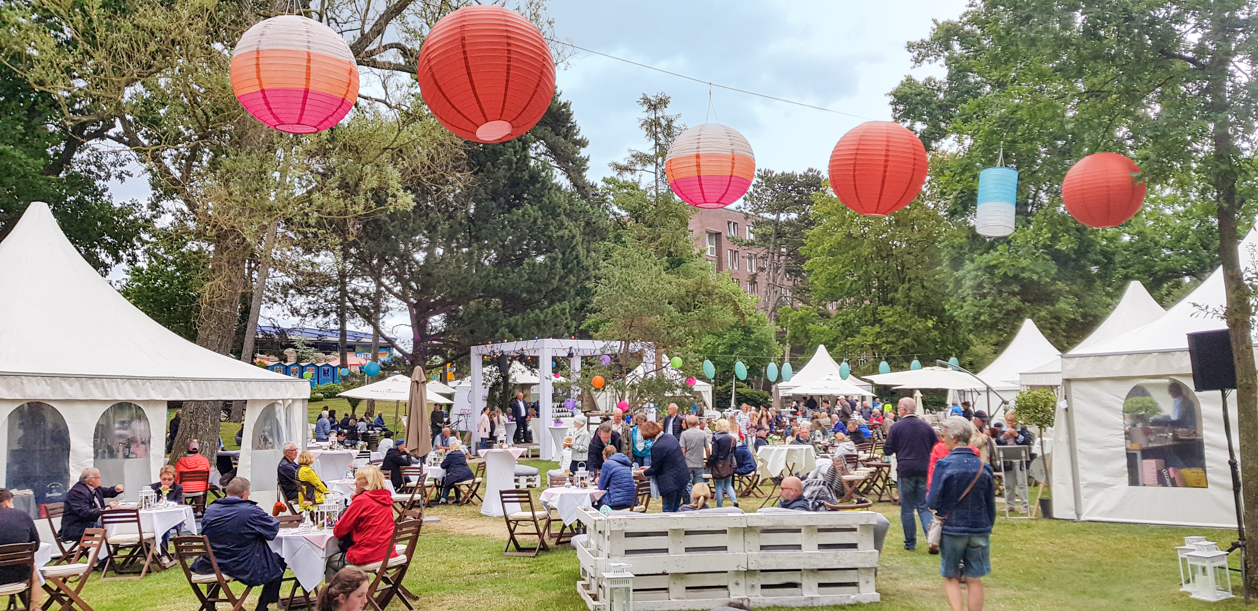 Festwiese mit vielen weißen Zelten und Tischen und Stühlen dazwischen.