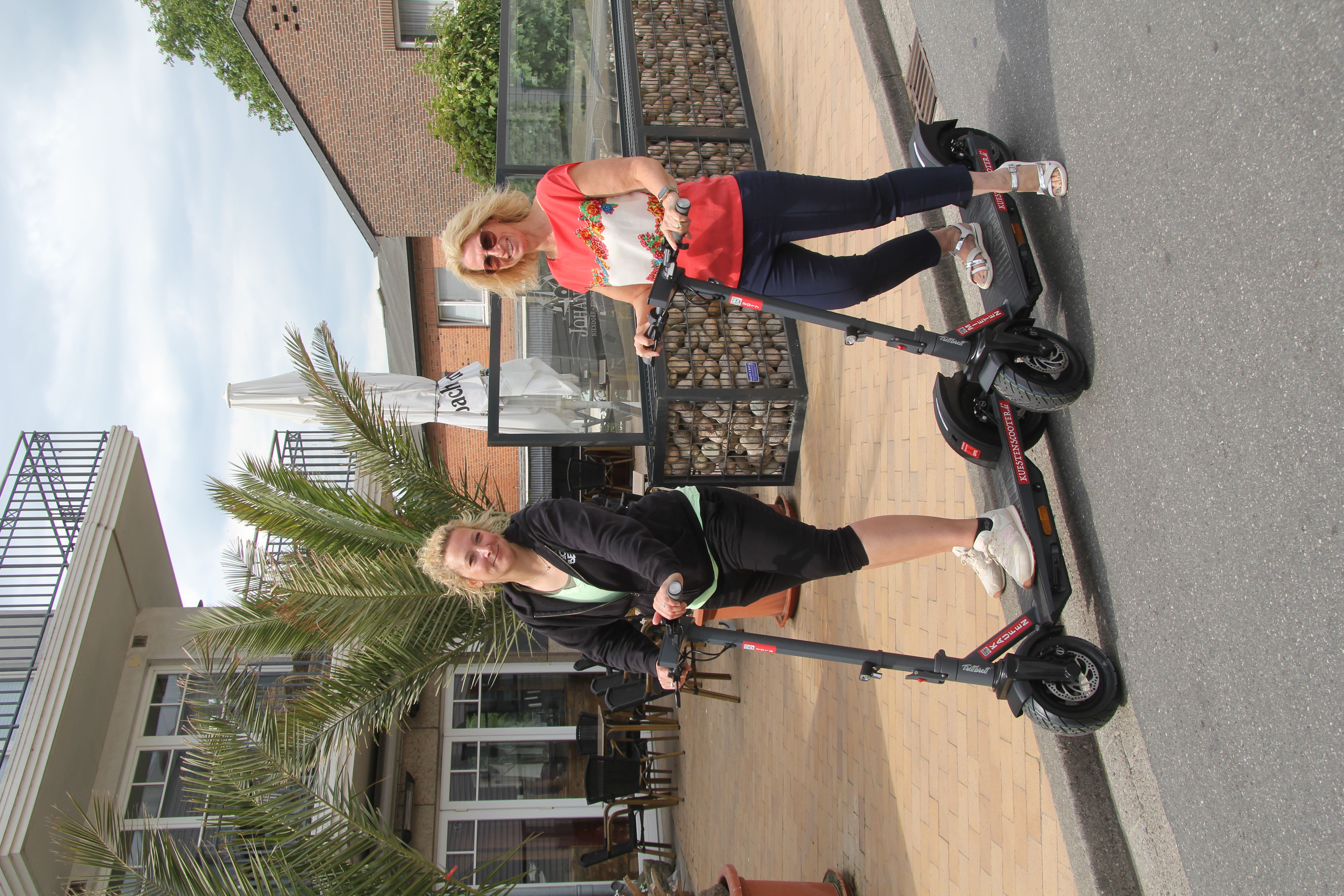 Zwei Frauen auf E-Scootern in der Innenstadt