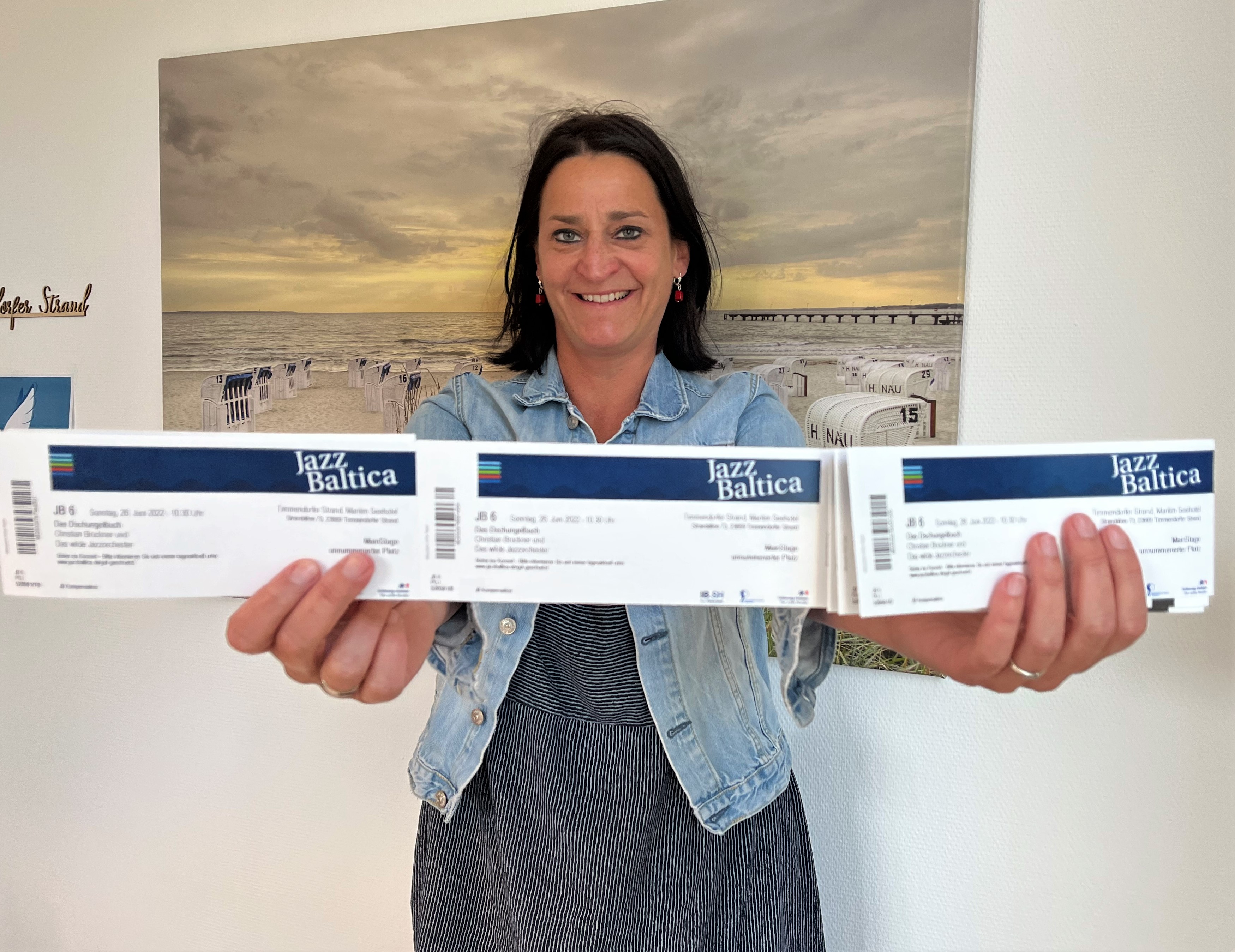 Eine Frau hält drei Jazz Baltica Tickets in die Kamera