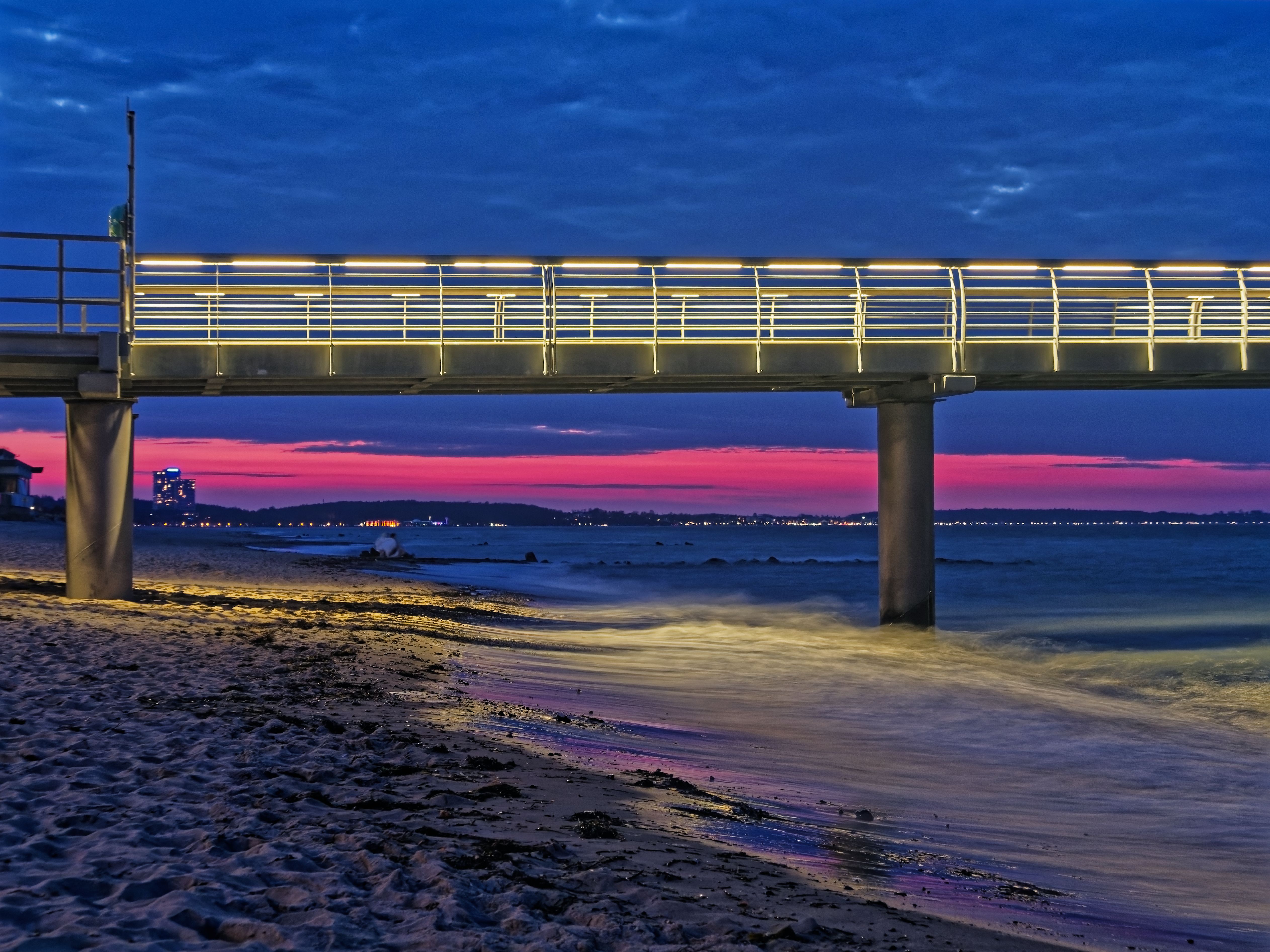 Teilausschnitt der Seebrücke in der Abenddämmerung mit pink erleuchtetem Himmel