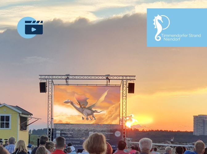 Viele Menschen schauen einen Film auf einer Leinwand am Strand im Abendrot