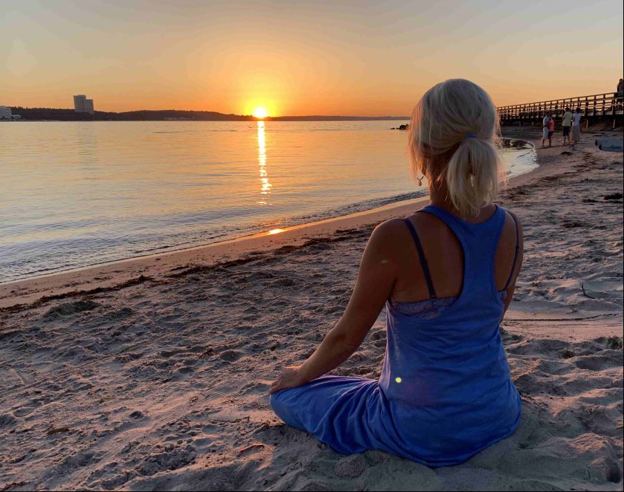 Eine Frau macht Yoga am Strand